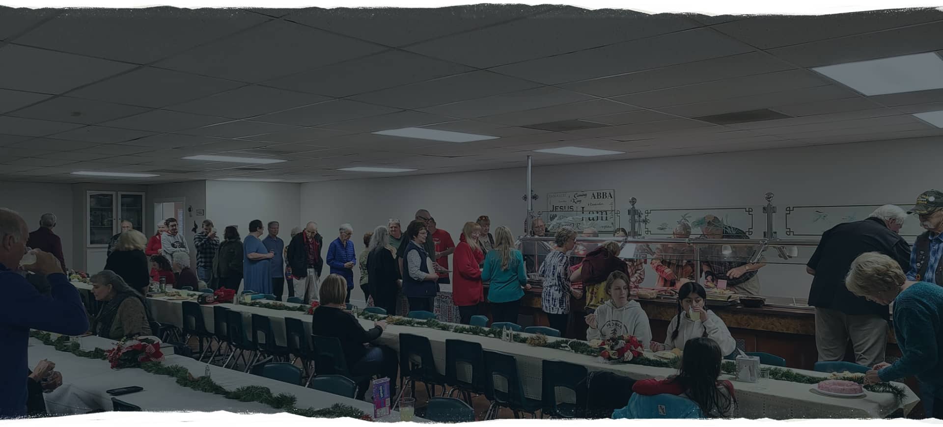 Image presents a picture of a church potluck gathering to support the News web page for Jubilation Fellowship church that provided details, dates, and times, about church happenings, such as worship service, intercession, children's ministries, youth ministries, women's ministries, men's ministries, elder and board meetings, evangelism, and outreach to help the needy.